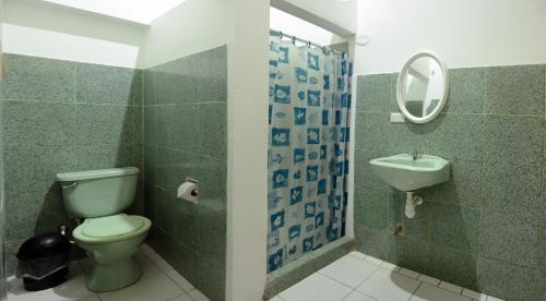 bagno con servizi igienici, lavandino e specchio di Hostal Casa Blanca a Tarapoto