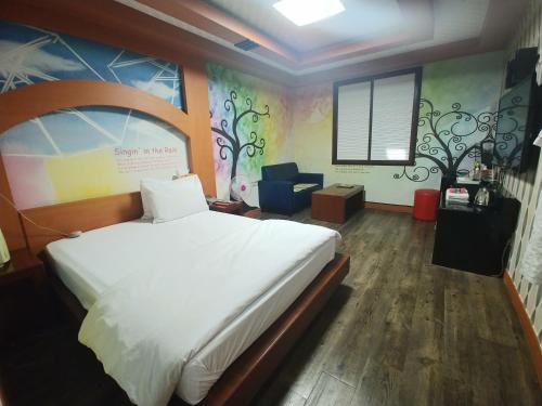 una camera con un grande letto bianco di New Grand Hotel a Daegu