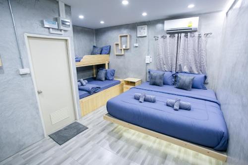 um quarto azul com 2 camas e um espelho em Classiccar Caravan em Chai Nat