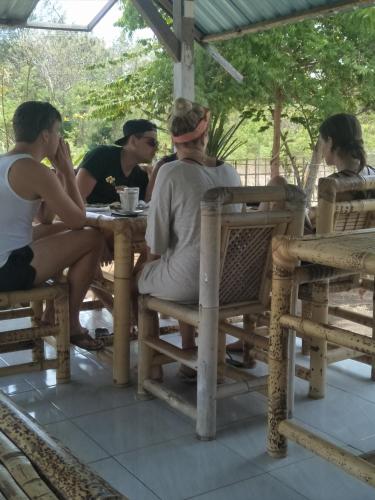 un gruppo di persone sedute a un tavolo di Dinoyin Bungalows a Gili Meno