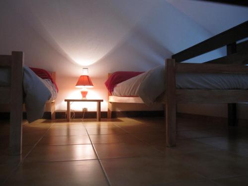 Zimmer mit 2 Betten und einem Tisch mit einer Lampe in der Unterkunft Le Relais De Clavières in Clavières-de-Montagne