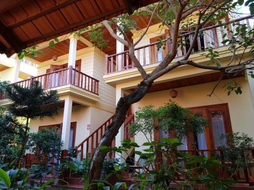 a building with a tree in front of it at Free Beach Resort in Phu Quoc