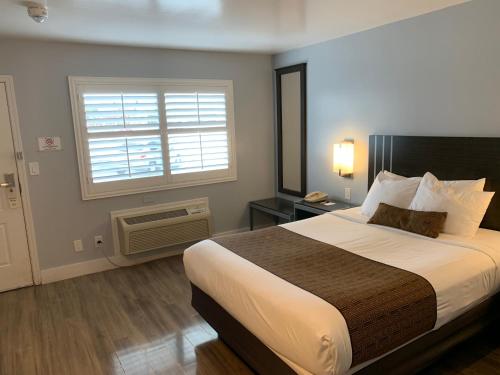um quarto de hotel com uma cama grande e uma janela em Pacific Inn Monterey em Monterey