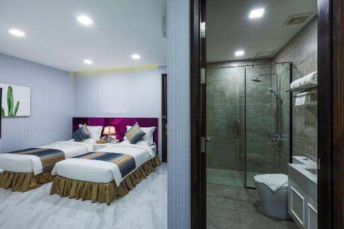 a hotel room with two beds and a shower at V Boutique Hotel in Phnom Penh