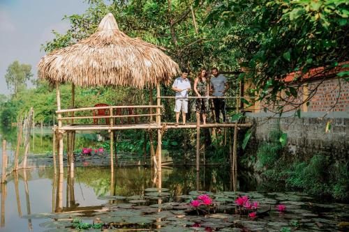 a group of people standing on a bridge over a pond at Hoang Giang Homestay in Ninh Binh