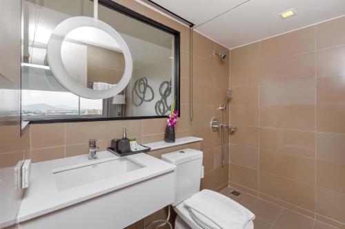 a bathroom with a toilet, sink and mirror at Pearl Hotel - SHA Plus in Phuket