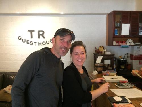 a man and a woman standing next to a counter at TR Guesthouse in Sukhothai