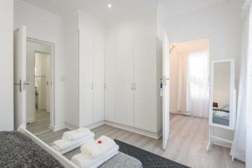 a white room with white walls and a mirror at Rinkink Beach House in Wilderness