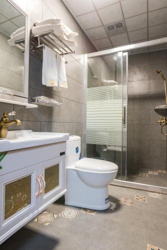 a bathroom with a toilet and a sink and a shower at Chaozhou Hello Inn in Chaozhou