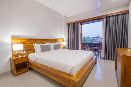 a bedroom with a large bed and a large window at Umala at Bisma in Ubud