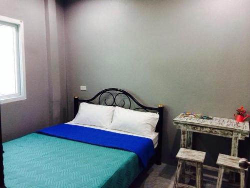 a bedroom with a bed and a side table at K Guesthouse Adults only in Krabi town