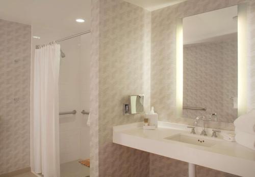 a bathroom with a sink and a mirror and a shower at Hyatt Regency Los Angeles International Airport in Los Angeles