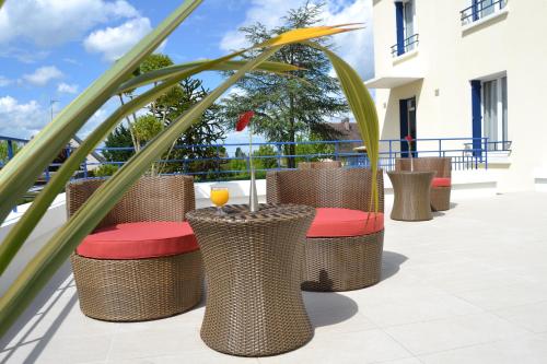 a row of wicker chairs and tables on a patio at Best Western Le Vinci Loire Valley in Amboise
