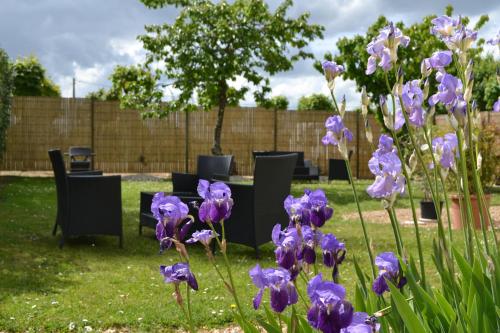 a bunch of purple irises in a yard with tables and chairs at Best Western Le Vinci Loire Valley in Amboise