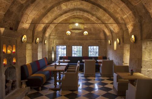 a restaurant with couches and tables in a stone building at Hezen Cave Hotel in Ortahisar
