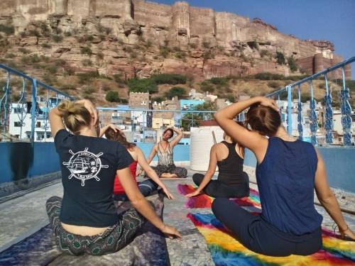 a group of women sitting on a balcony doing yoga at Yogis Guest House in Jodhpur