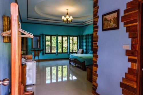 una camera da letto con pareti blu, un letto e finestre di Phachuanchom Resort Khaoyai a Mu Si