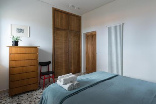 a bedroom with a bed and a dresser and towels at Terra Lavica Luxury Home Holidays in Nicolosi