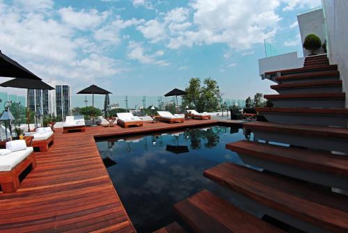 una piscina con sofás y sillas en un edificio en Demetria Hotel, en Guadalajara