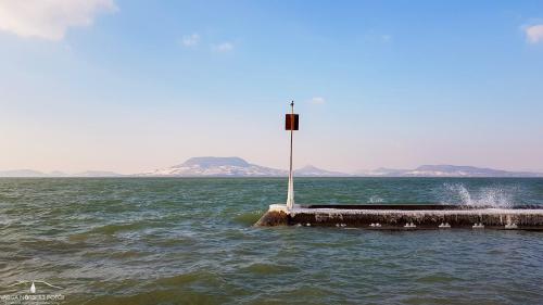 un poste en medio de un cuerpo de agua en Valentina apartman, en Balatonmáriafürdő