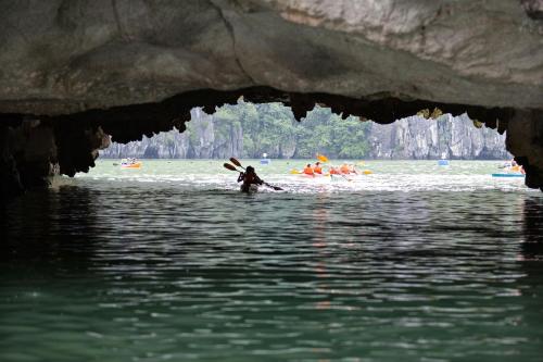 a person swimming in the water in a cave at Peony Cruises in Ha Long