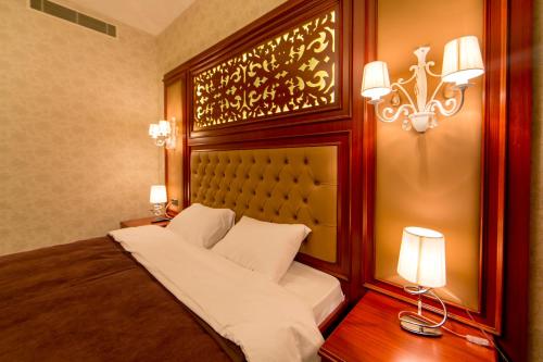 a bedroom with a bed and two lights and lamps at AZPETROL HOTEL MINGECHAUR in Mingachevir