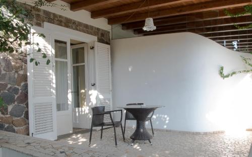 a patio with a table and chairs next to a door at Hotel Villa Enrica - Aeolian Charme in Lipari