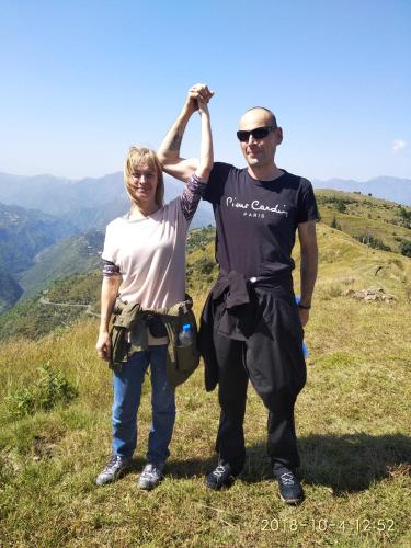 a man and a woman standing on top of a hill at Trimurti Pine Valley Resort in Shimla