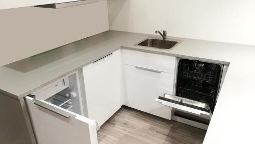 a white kitchen with a sink and a microwave at Comfortable Studio only 20 minutes from International Conference Center Katowice best place for WUF2022 EEC TNF OFF etc in Siemianowice Śląskie
