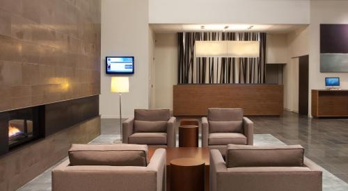a waiting room with chairs and a fireplace at Novotel Toronto Vaughan Centre in Vaughan