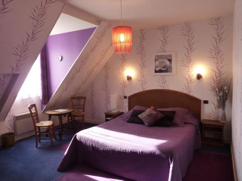 a bedroom with a purple bed and a staircase at Hôtel A La Renommée in Saint-Père