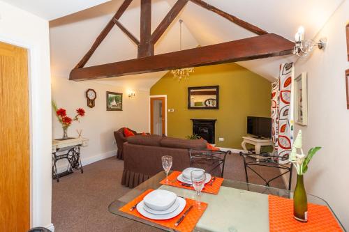 ein Wohnzimmer mit Sofa und Tisch in der Unterkunft Bodafon Hall Cottages in Llandudno