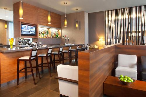 a bar in a restaurant with wooden walls and bar stools at Novotel Toronto Vaughan Centre in Vaughan