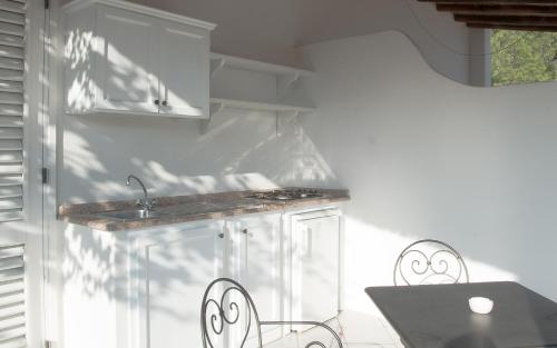 a kitchen with a sink and a table and chairs at Hotel Villa Enrica - Aeolian Charme in Lipari