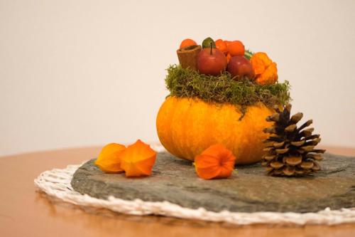 a pumpkin with fruit on top of a table at Anton‘s Souterrain-Wohnung in Eberfing
