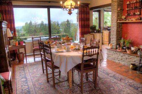 comedor con mesa, sillas y ventana en B&B Sol Magnus, en Stavelot