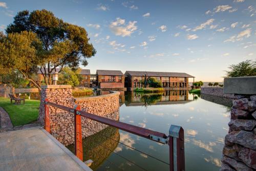 a bridge over a river in front of a building at Riboville Boutique Hotel And Restaurant in Midrand