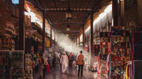 a group of people walking down a street in a market at MAZMI CASA in Dubai