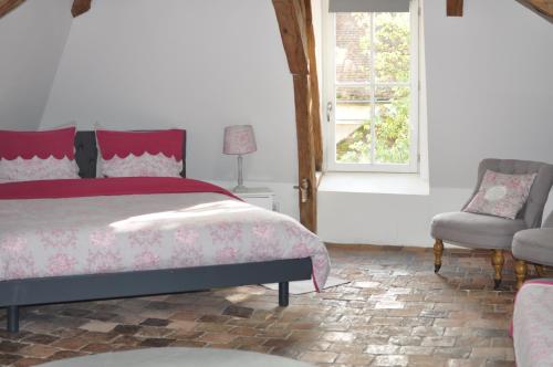 une chambre avec un lit, une fenêtre et une chaise dans l'établissement B&B Le Relais des Saints Pères, à Auxerre