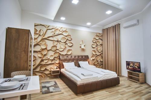 um quarto com uma cama e uma parede com um mural de árvore em K51 Apartman | Budapest em Budapeste