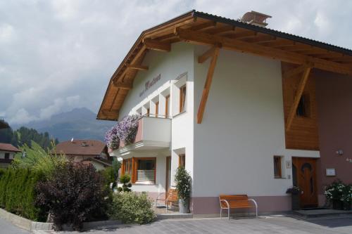 a large white building with a wooden roof at Apart Montana in Nauders