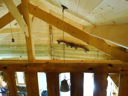 a wooden ceiling with two bells hanging from it at Etangs du Moulin in Suzy