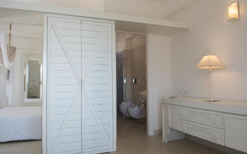 a white sliding door in a bedroom with a bathroom at Hotel Villa Enrica - Aeolian Charme in Lipari