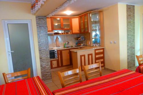 une cuisine avec des armoires orange et une table et des chaises rouges dans l'établissement Комплекс "Тера Верде", à Oreshak