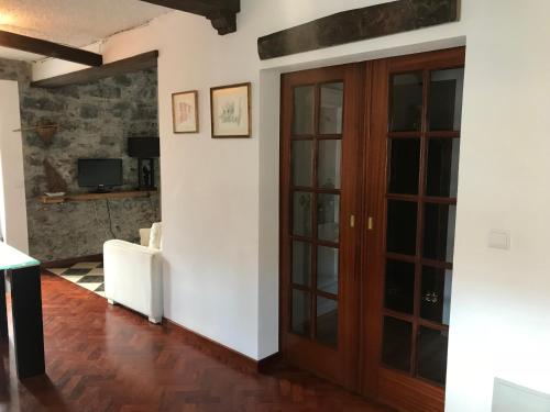 a hallway with a wooden door and a living room at Casa do Poço Funchal in Funchal