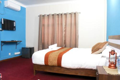a bedroom with a large bed and a tv at Gorkha Chhen bed & breakfast in Gorkhā