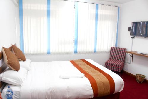 a hotel room with a bed and a chair at Gorkha Chhen bed & breakfast in Gorkhā