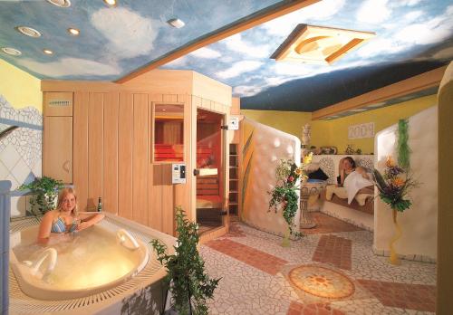 a woman sitting in a bath tub in a room at Landgasthof Schmidbaur in Donauwörth