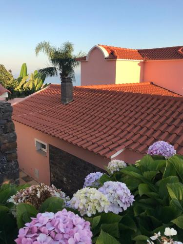 a house with a red roof and some flowers at Casa do Poço Funchal in Funchal