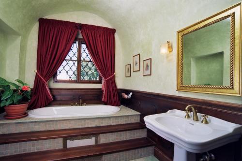 a bathroom with a tub and a sink and a window at Zámek Jemniště in Postupice